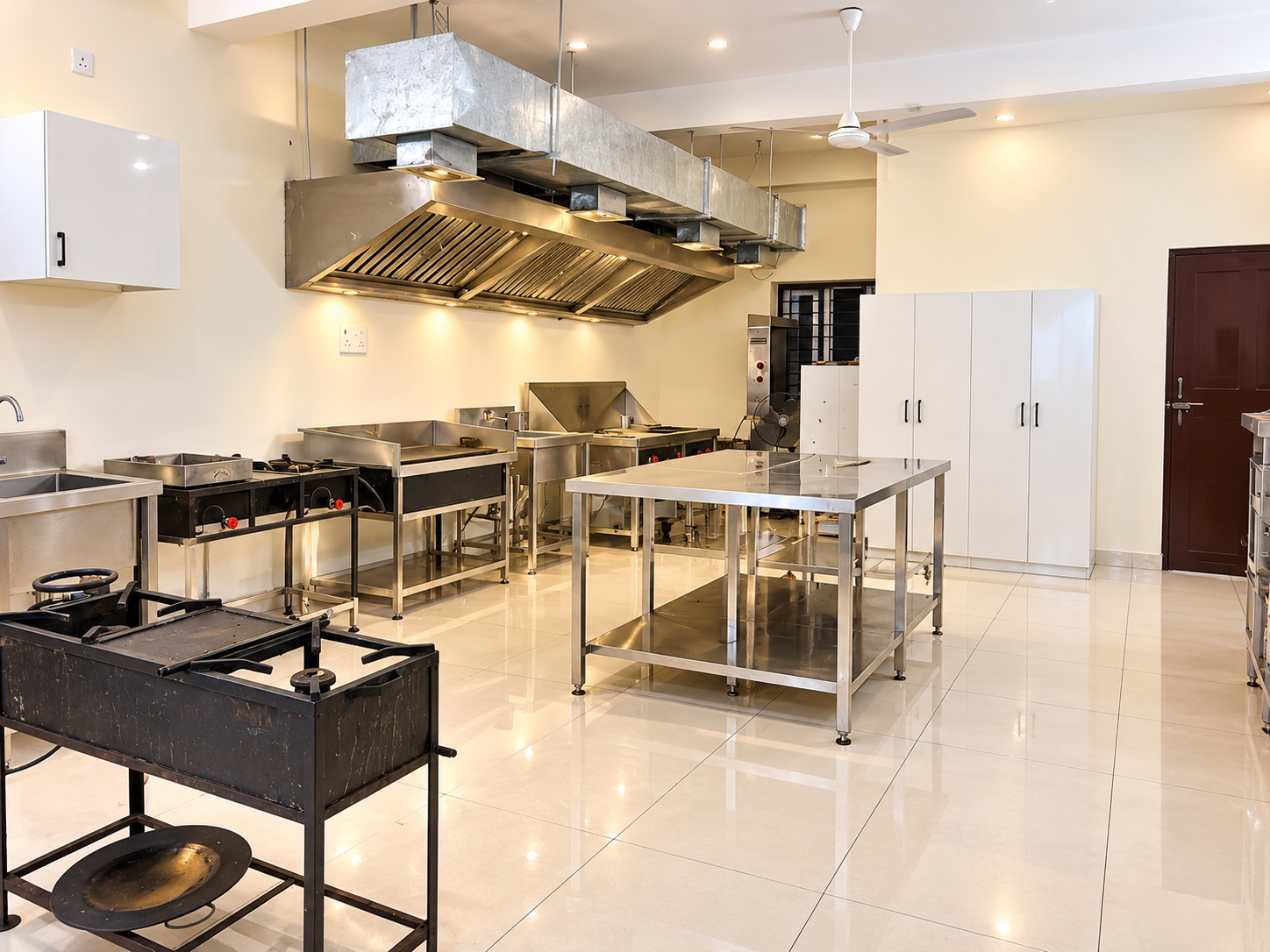 Fine Dine Academy professional cooking area with burners, steel work table and exhaust hood