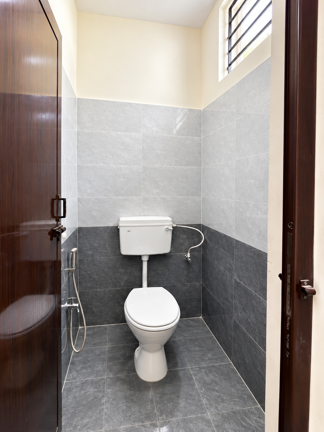 Fine Dine Academy restroom with toilet, handheld spray and tiled walls